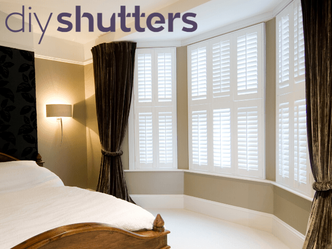 White bay window shutter blinds in bedroom